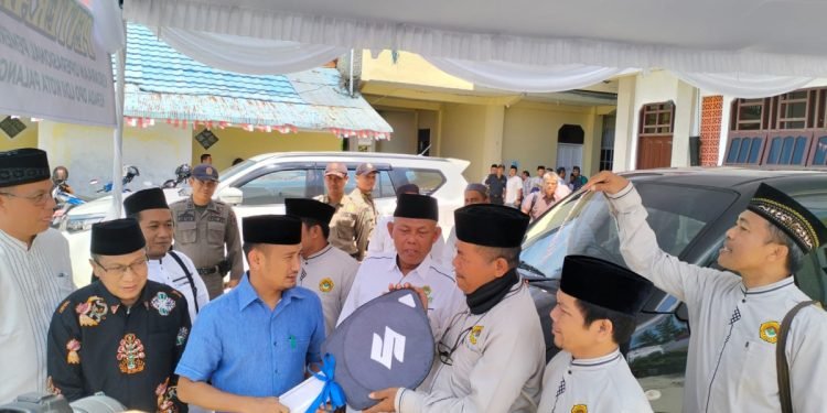 BANTUAN: Wali Kota Palangka Raya Fairid Naparin (baju biru) menyerahkan secara simbolik mobil operasional kepada Ketua DPD LDII Kota Palangka Raya HM Cholidin di halaman Masjid Jamiatul Amaliyah, Minggu (13/8). Foto: Imam Maftuh