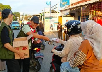 Pengurus PC LDII Pancoran Mas bersama anggota Pramuka SAKO SPN saat membagikan paket takjil kepada pengguna jalan Pitara Pancoran Mas Depok, Jumat (22/3). (LINES)