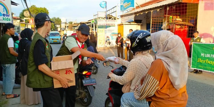 Pengurus PC LDII Pancoran Mas bersama anggota Pramuka SAKO SPN saat membagikan paket takjil kepada pengguna jalan Pitara Pancoran Mas Depok, Jumat (22/3). (LINES)