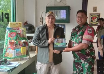 Ketua PC LDII Cimanggis Hady Dwi Purbaya menyerahkan kalender LDII tahun 2025 kepada petugas piket Koramil 06 Cimanggis. (LINES)